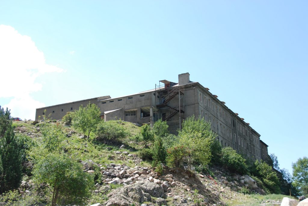 Exterior del antiguo edificio del Balneario de Benasque entre laderas de montaña, fotografía histórica de 2009