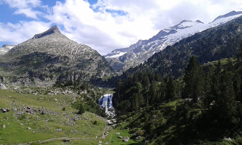 Cascada y entorno del Forau de Aigualluts, en el valle de Benasque, con las montañas del Aneto al fondo