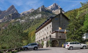 Fachada del Parador de Bielsa en el valle de Pineta, con las montañas del Pirineo detrás